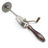 Vintage metal tool with wooden handle on a white background